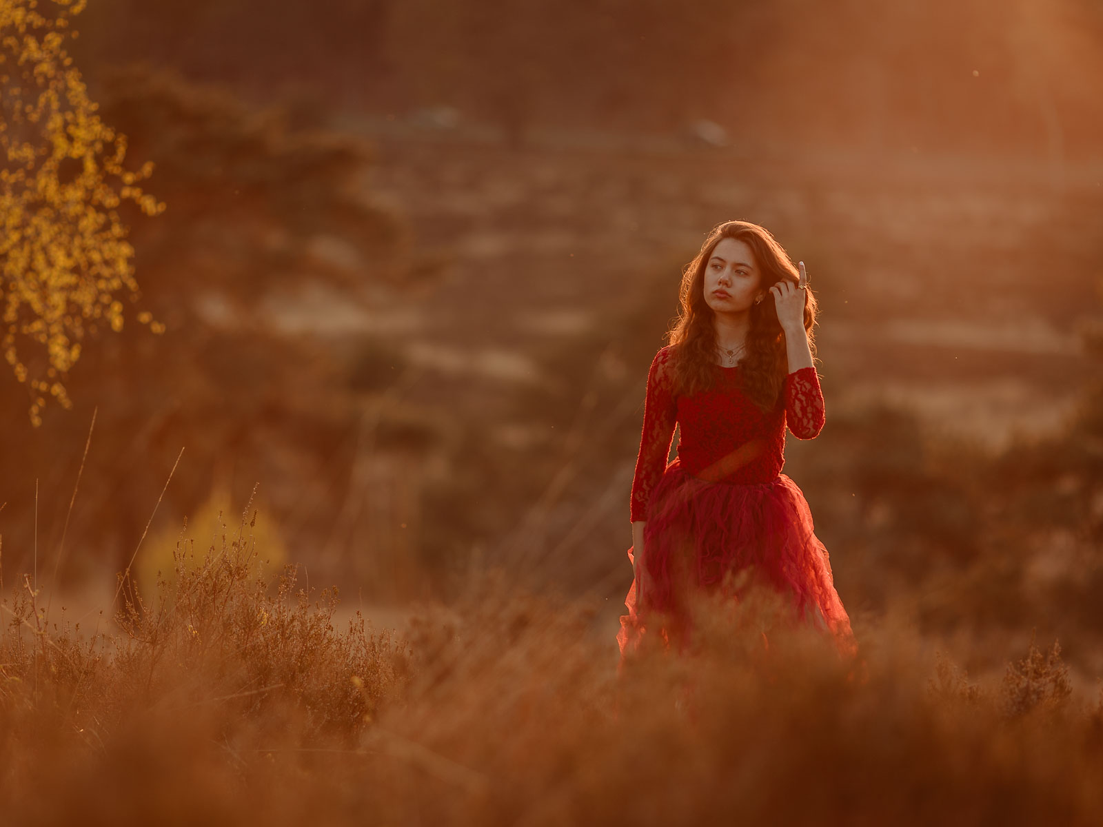 Meisje in rode jurk bij zonsondergang